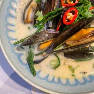 Fresh Thai mussels in creamy coconut broth with vibrant samphire garnish