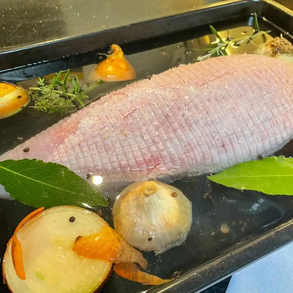 Turkey crown submerged in homemade brine before roasting