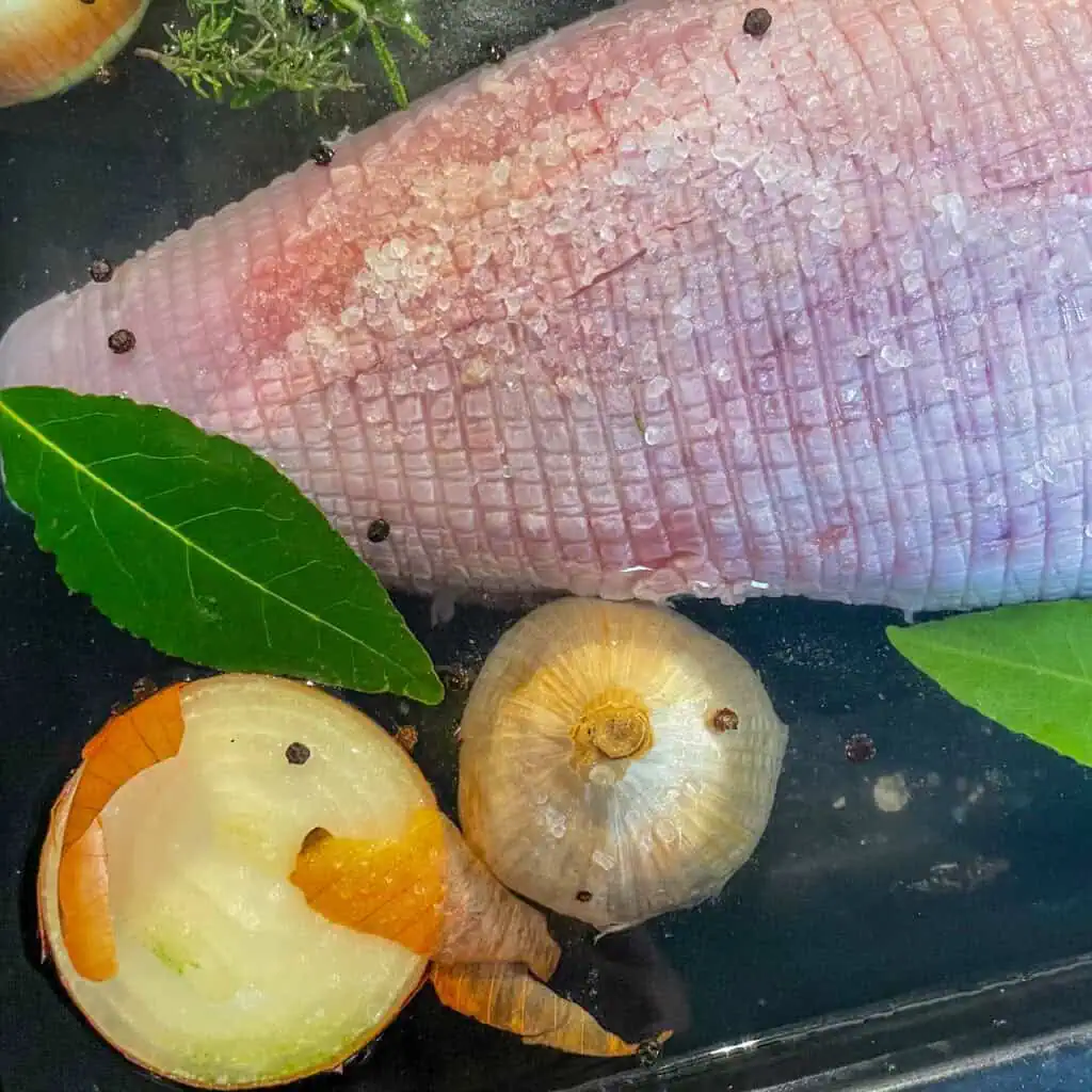Whole turkey crown resting in herb and garlic brine ready for roasting