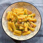 Steaming hot kimchi pea pasta garnished with Parmesan cheese