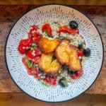 Top view of halloumi and pearl couscous salad in a white bowl on a wooden table