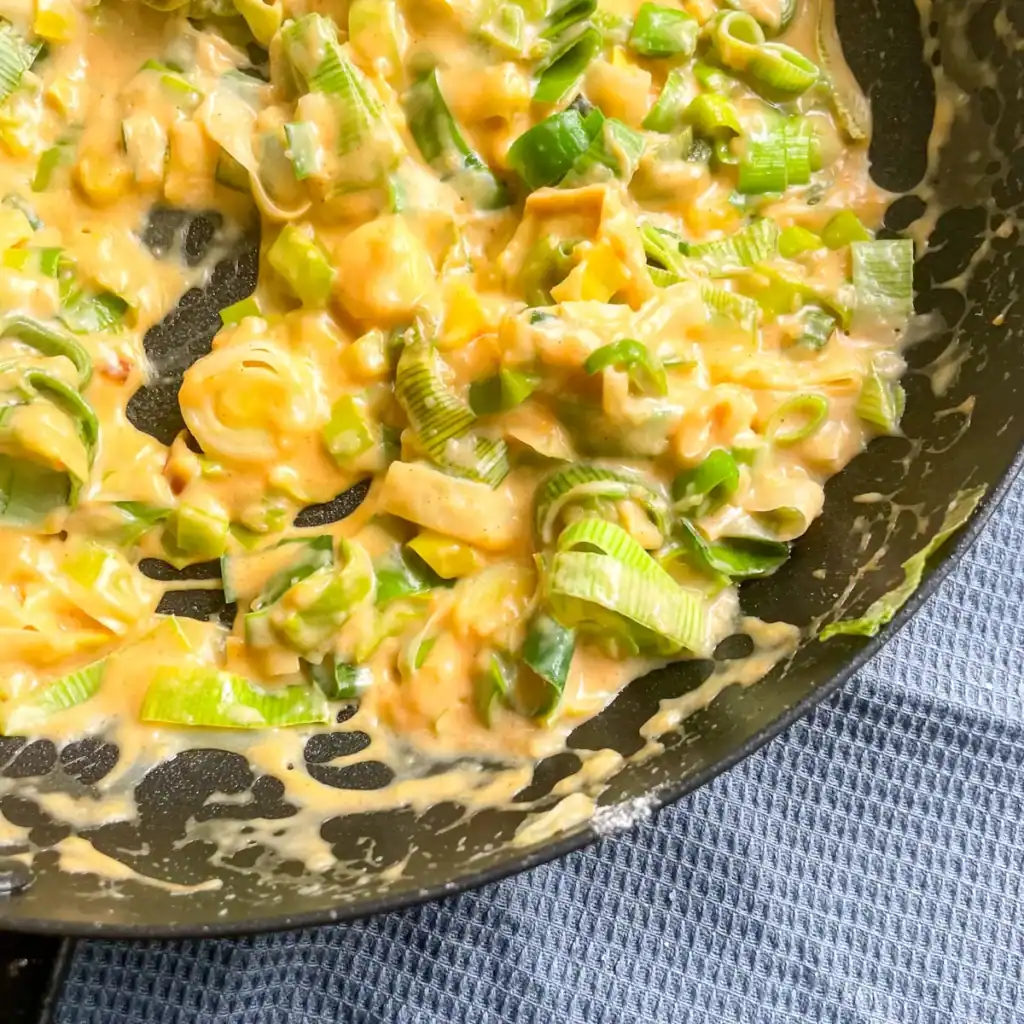 creamy leeks in a pan on a blue table cloth