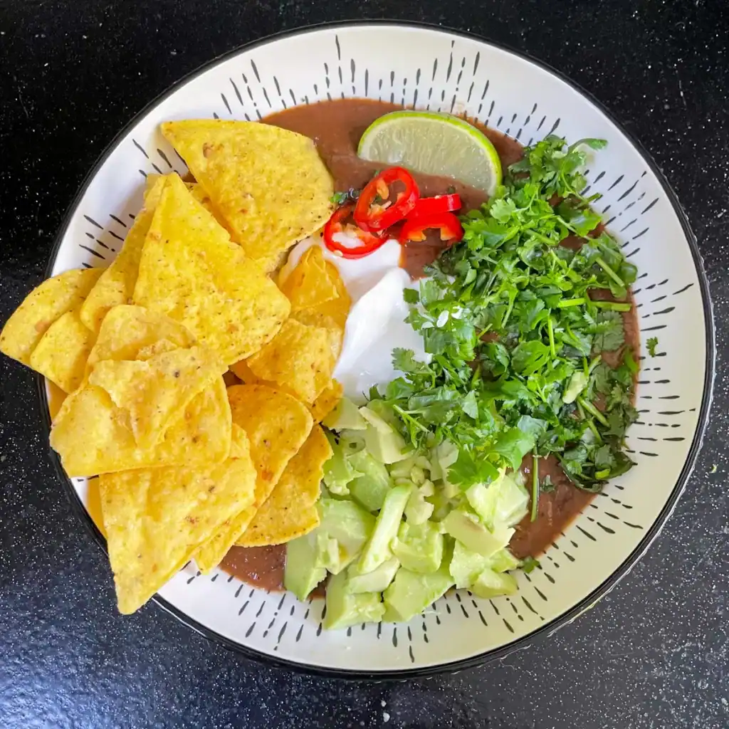 loaded black bean soup with tortillas avocado and coriander