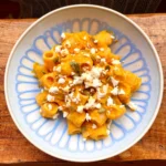 butternut squash pasta topped with feta in a blue bowl