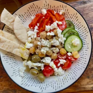 Mediterranean style hummus bowl with salad and pita