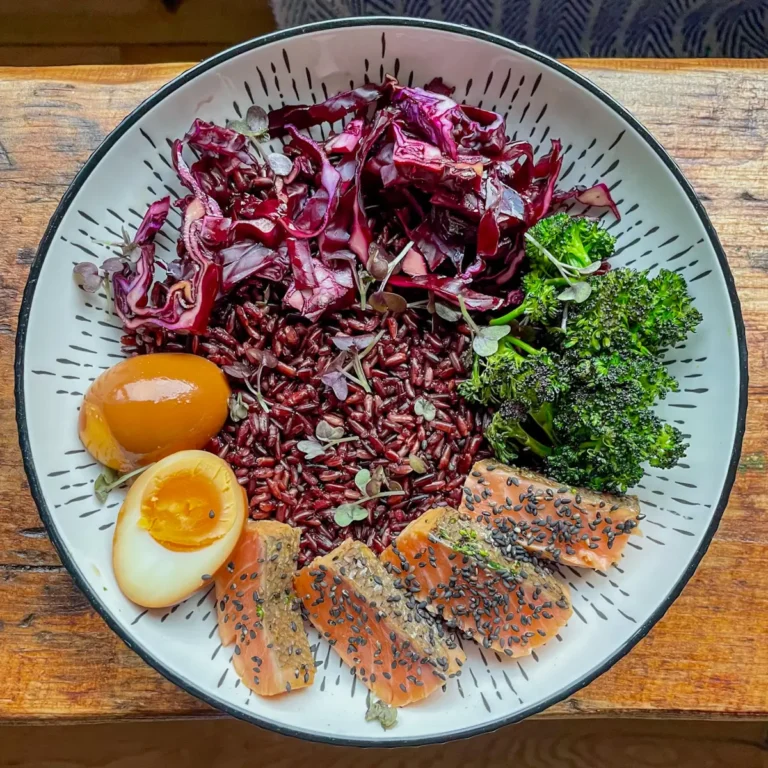Salmon rice bowl topped with eggs, broccoli and cabbage