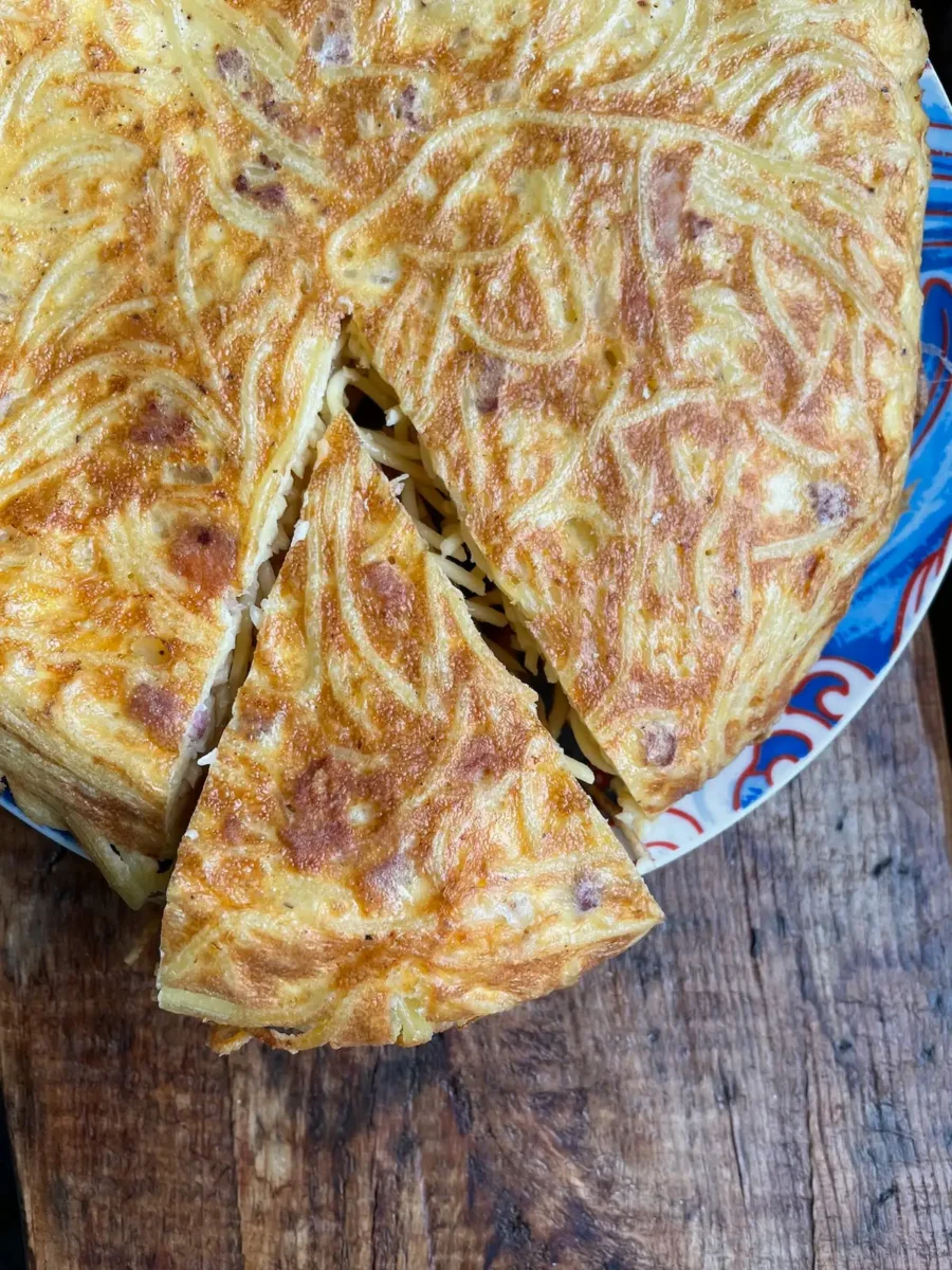spaghetti tortilla cooked until golden with a slice cut out of it