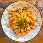 a white bowl filled with baked feta and chorizo pasta