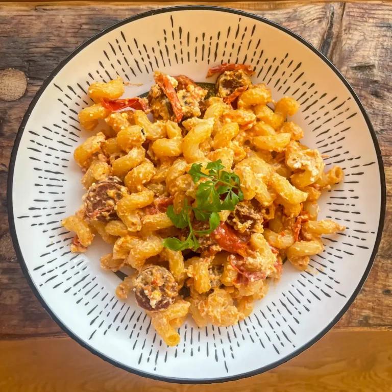 a white bowl filled with baked feta and chorizo pasta