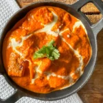 butter halloumi curry in a black cast iron dish