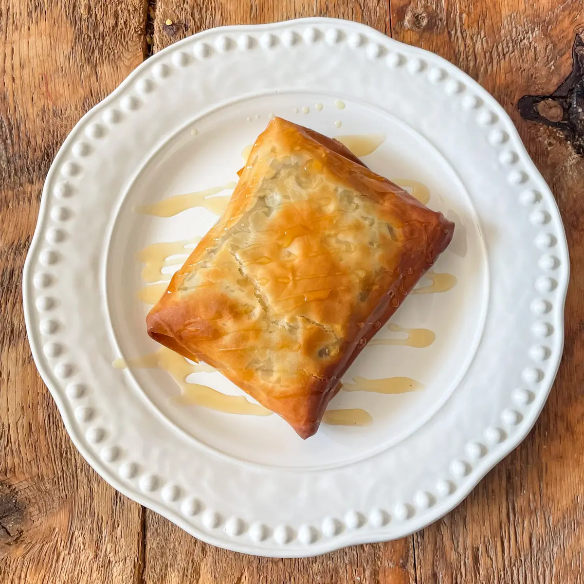 overhead image of a feta and blackcurrant filo pie drizzled with hot honey