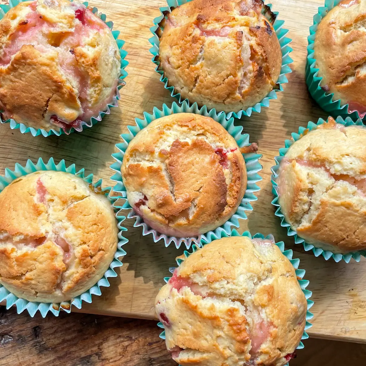 a selection of gooseberry muffins on a wooden board
