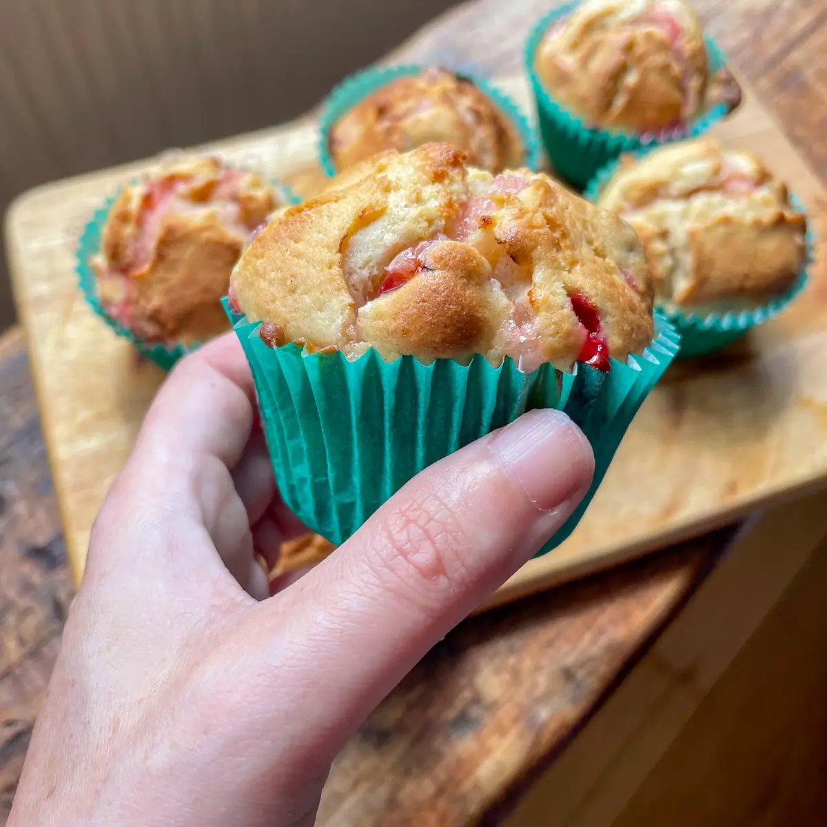 a hand holding a gooseberry muffin in a green case