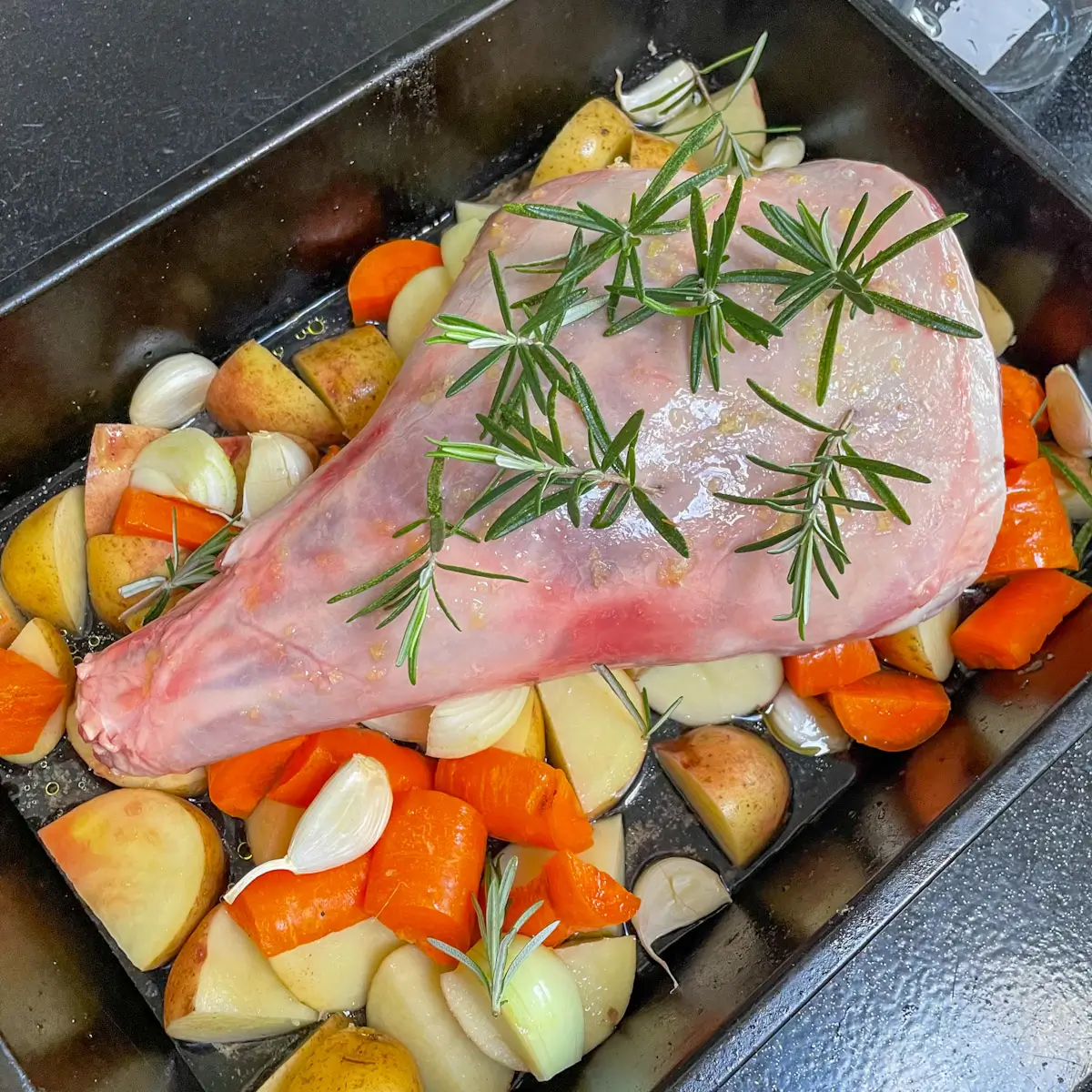 adding garlic and rosemary to lamb before cooking