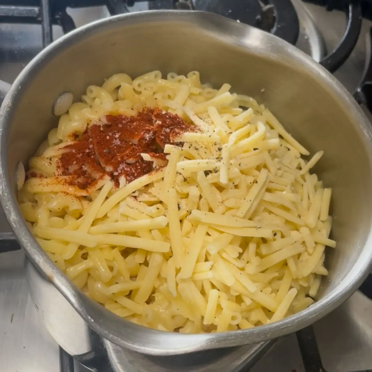 adding cheese, smoked paprika and mustard to stovetop Mac and cheese