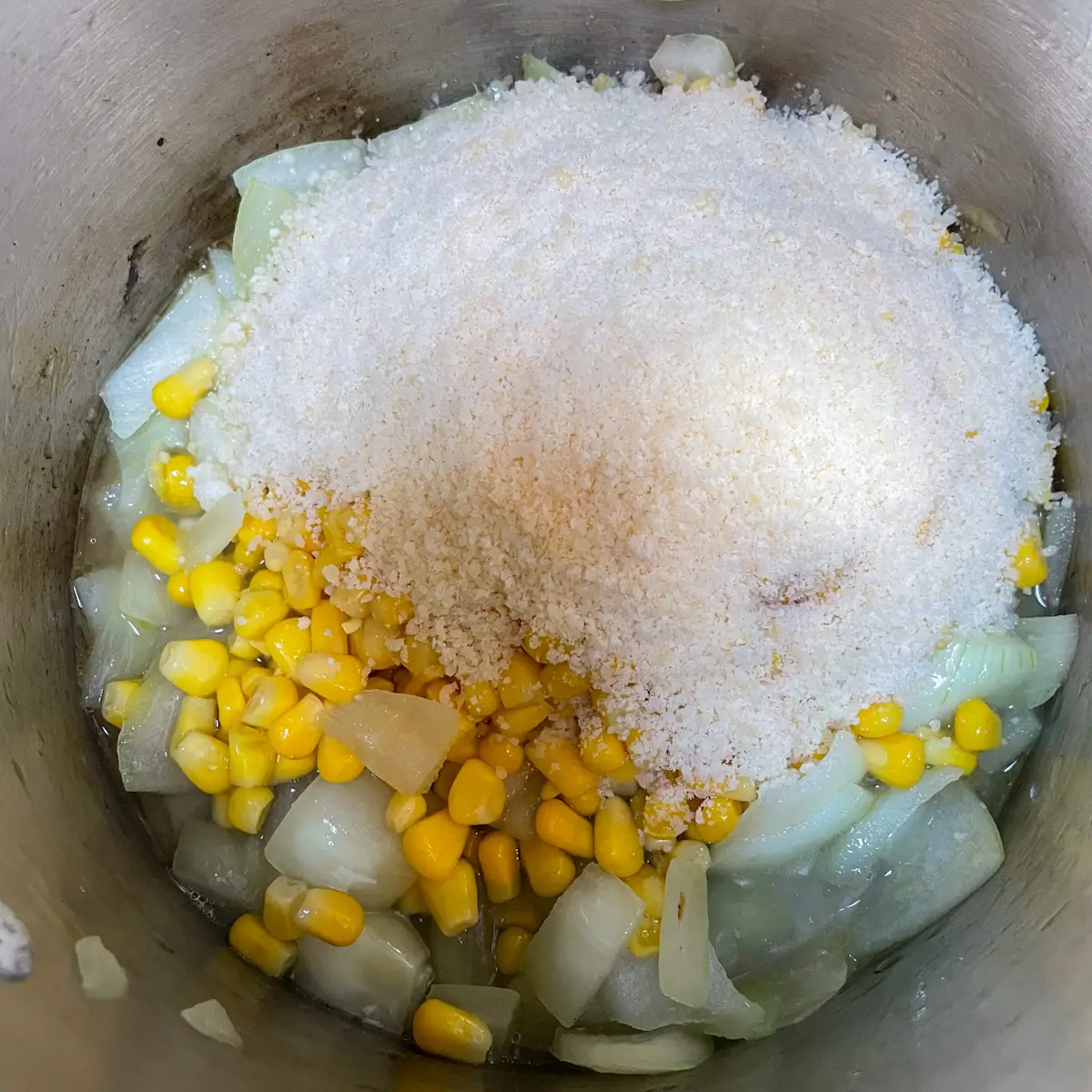 adding sweetcorn and parmesan to the pan