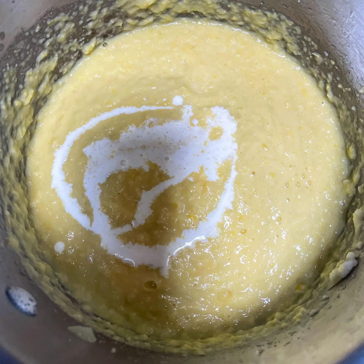 adding cream to the blended sweetcorn sauce