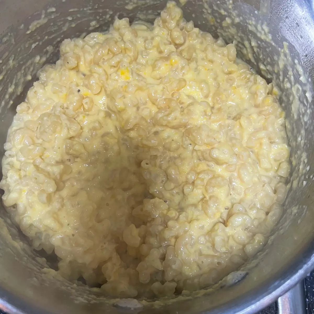 mixing together pasta and sweetcorn sauce