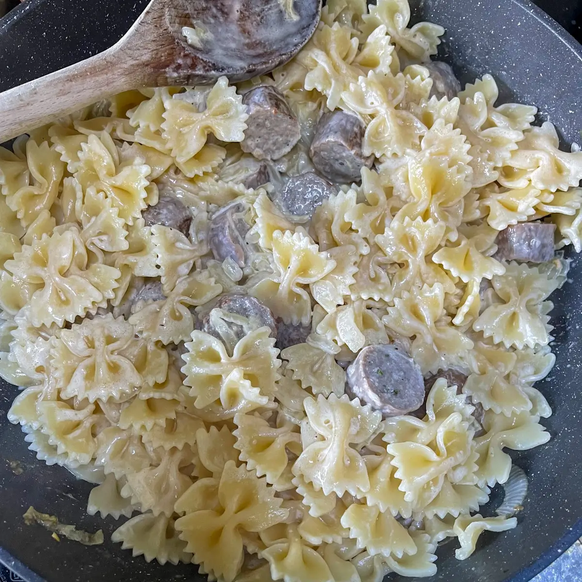 stirring pasta into the sauce