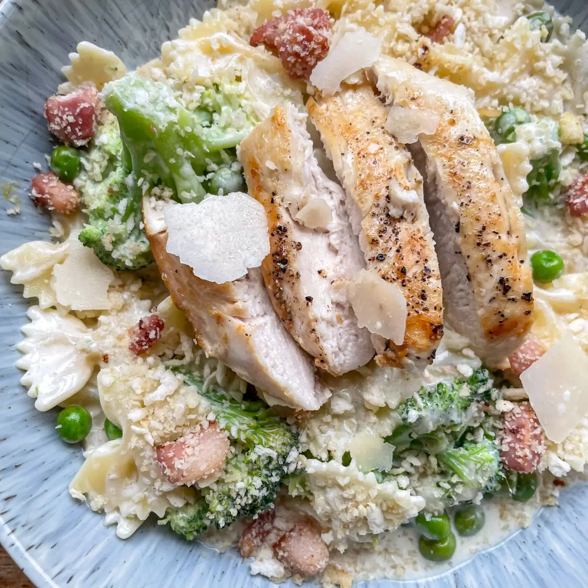 close up of chicken Caesar pasta in a blue bowl