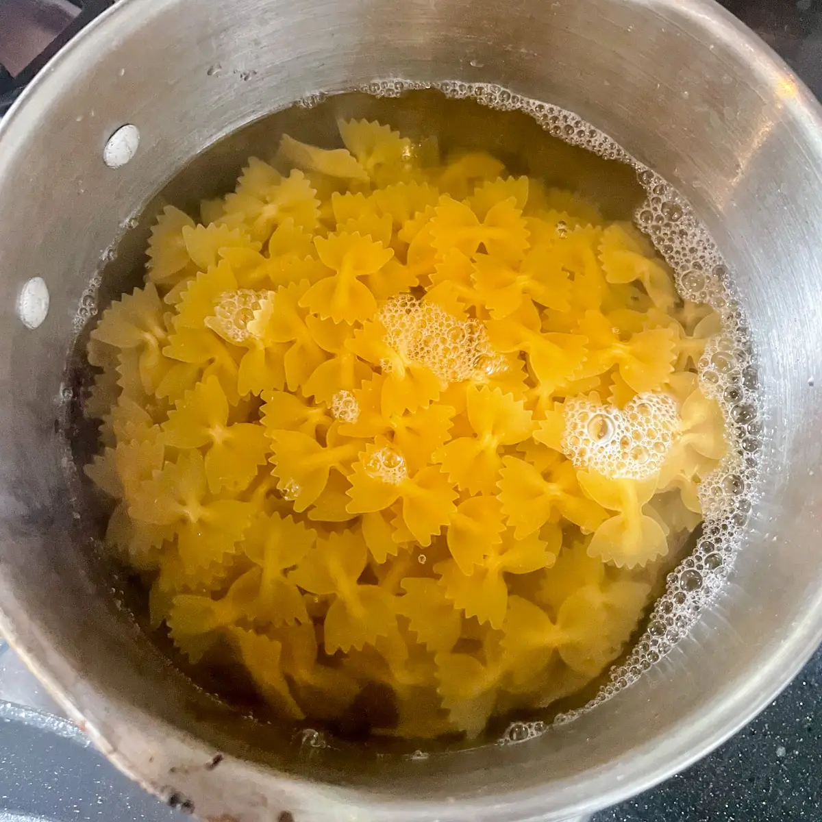cooking farfalle pasta in a pan of boiling water