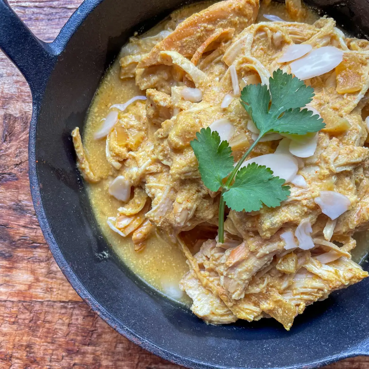 close up of chicken honey badami topped with flaked almonds and coriander