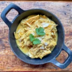 chicken honey badami curry in a cast iron dish