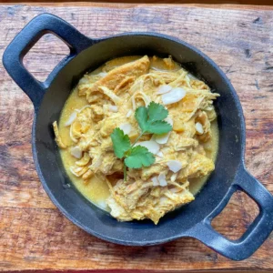 chicken honey badami curry in a cast iron dish