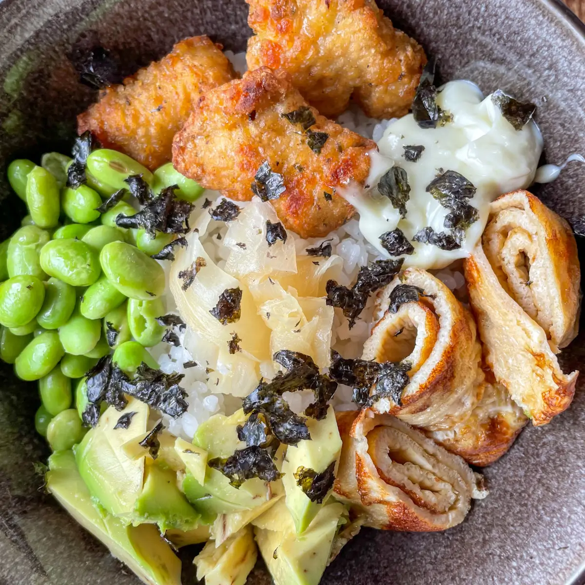sushi rice bowl with chicken nuggets assembled in a bowl