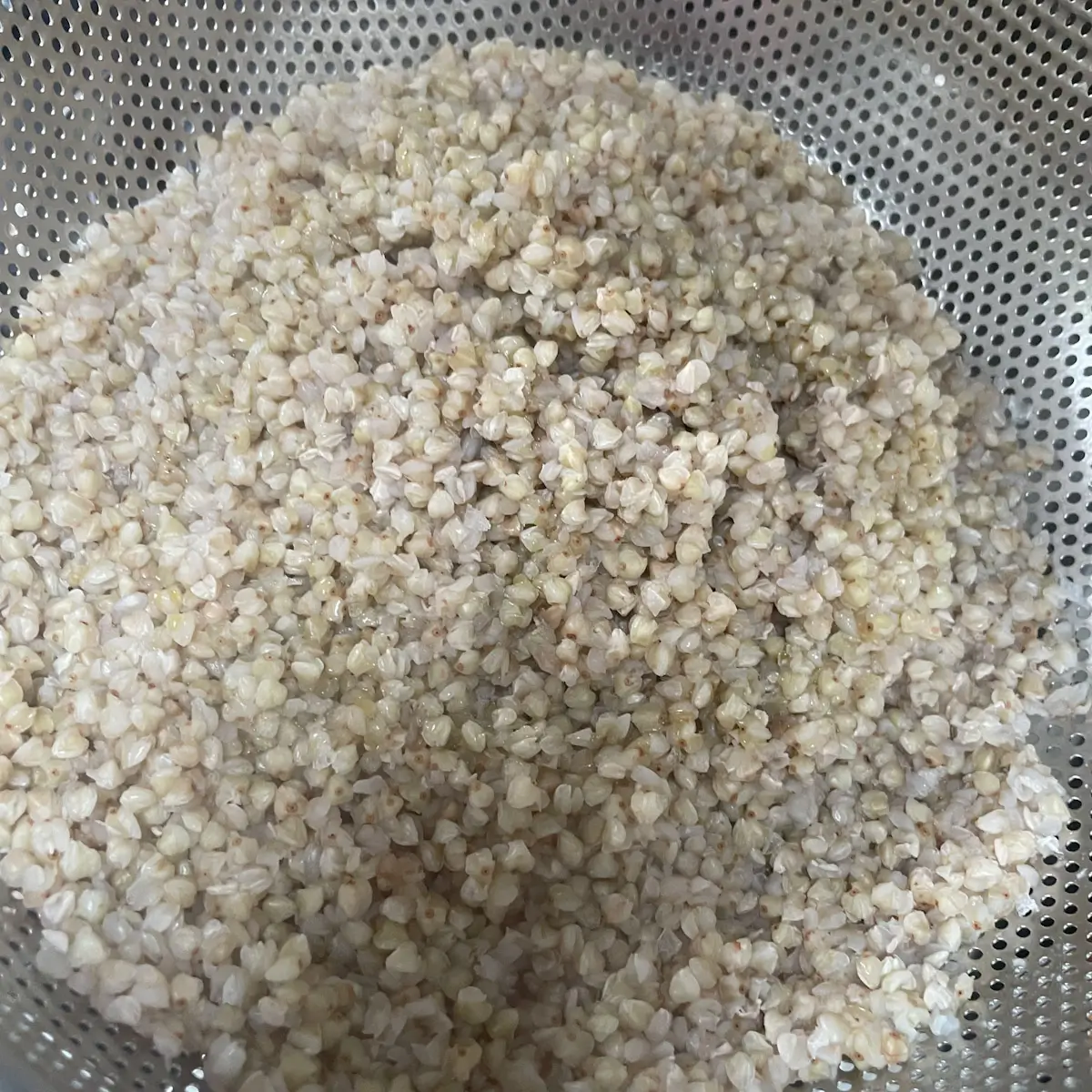 Cooked buckwheat being drained after cooking
