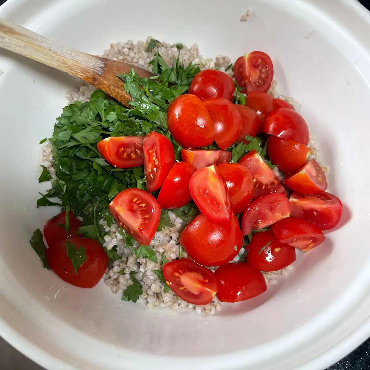 Mixing tomatoes, buckwheat, parsley and lemon juice in a bowl