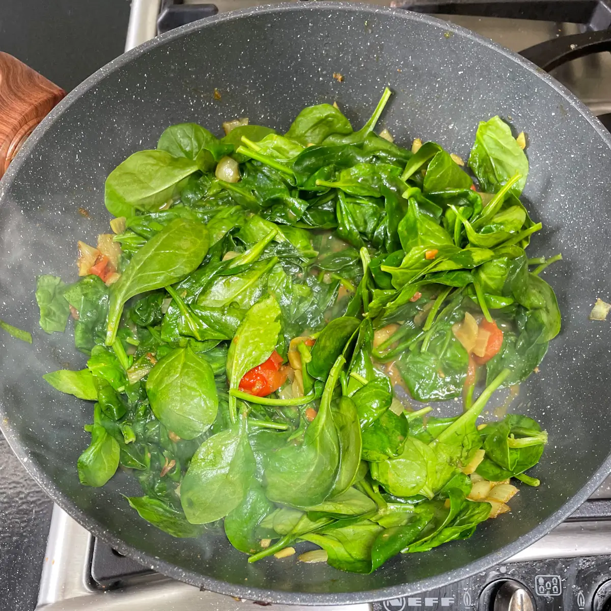 Cooking spinach in the pan until it wilts