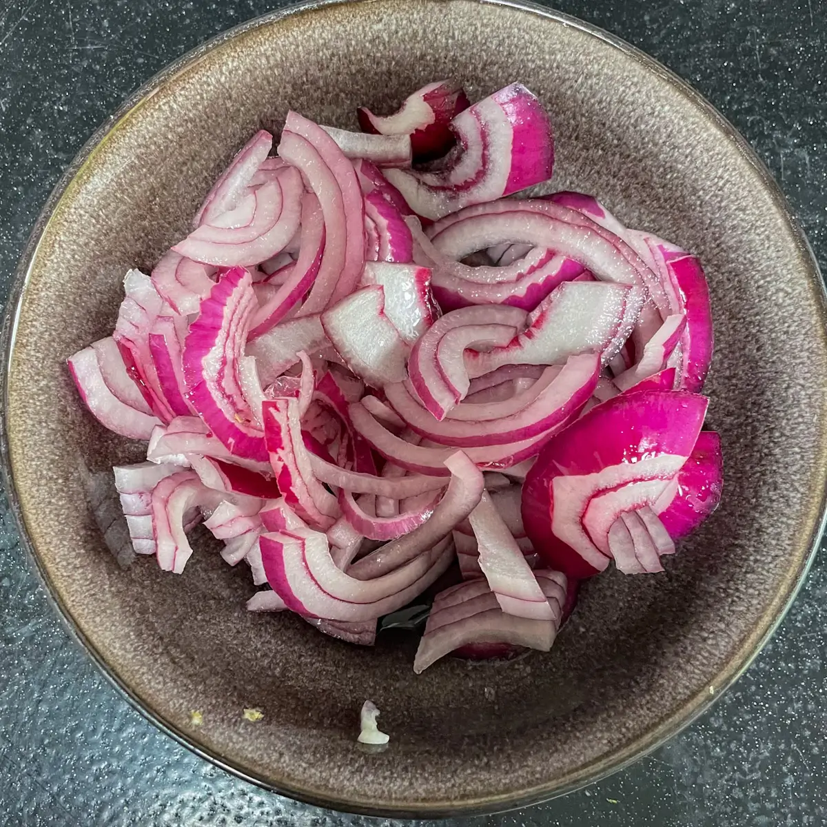 pickling red onions in a bowl