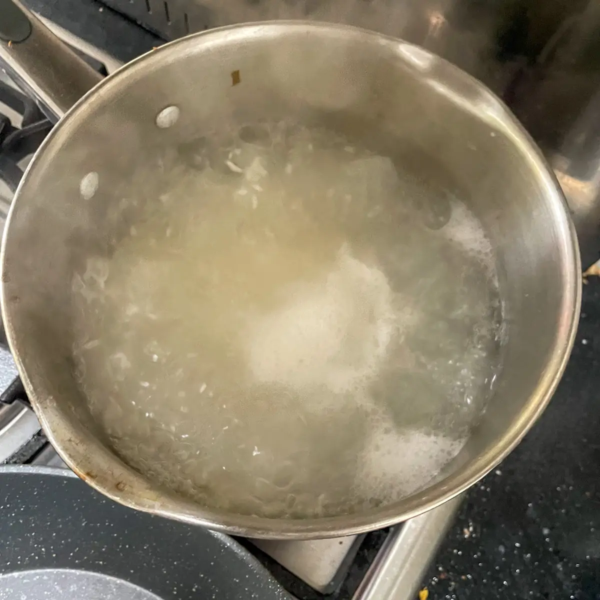 cooking sticky thai rice in a saucepan